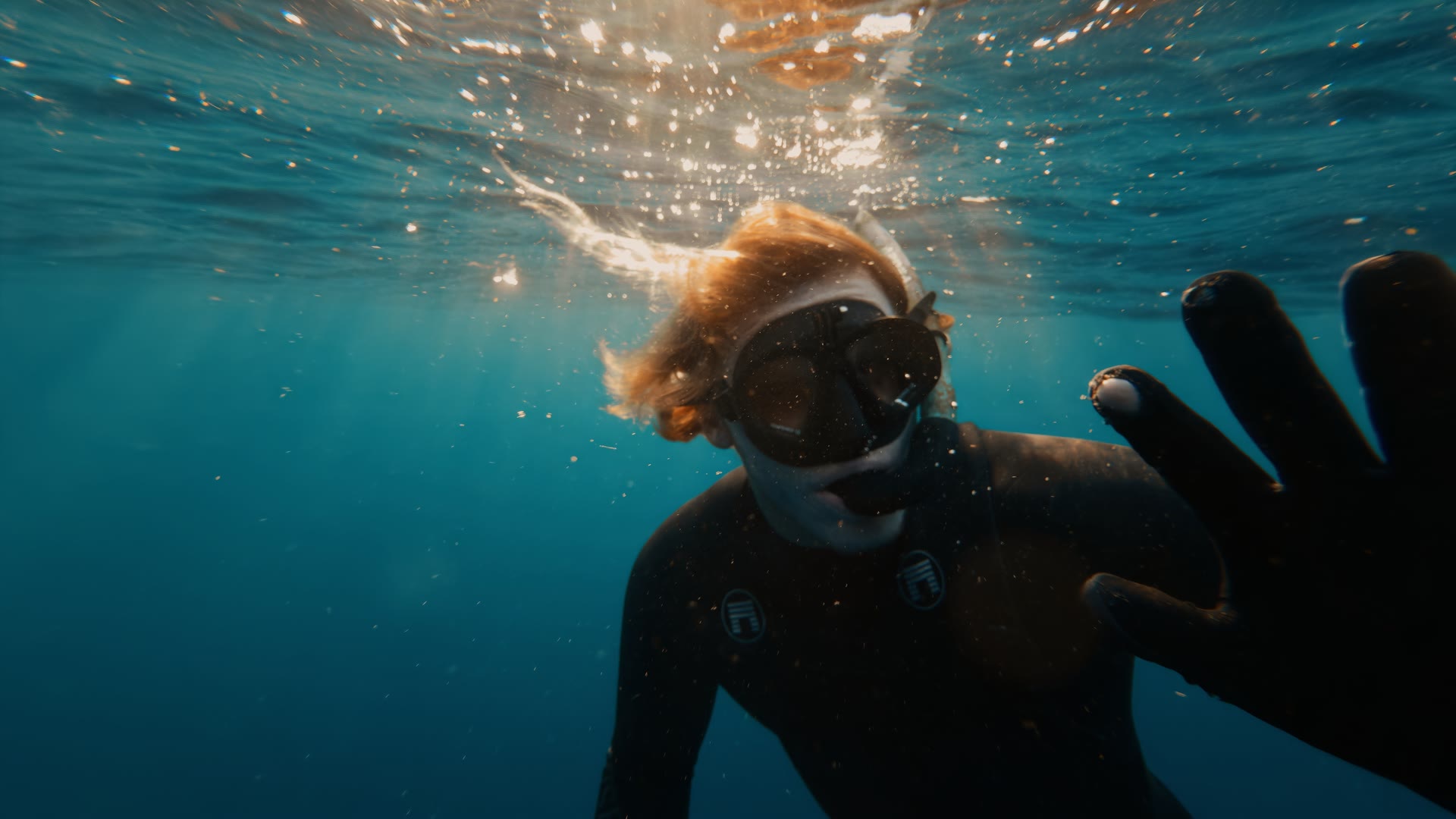 Diver waving with a hand in the lens, graded with AQUA PG
